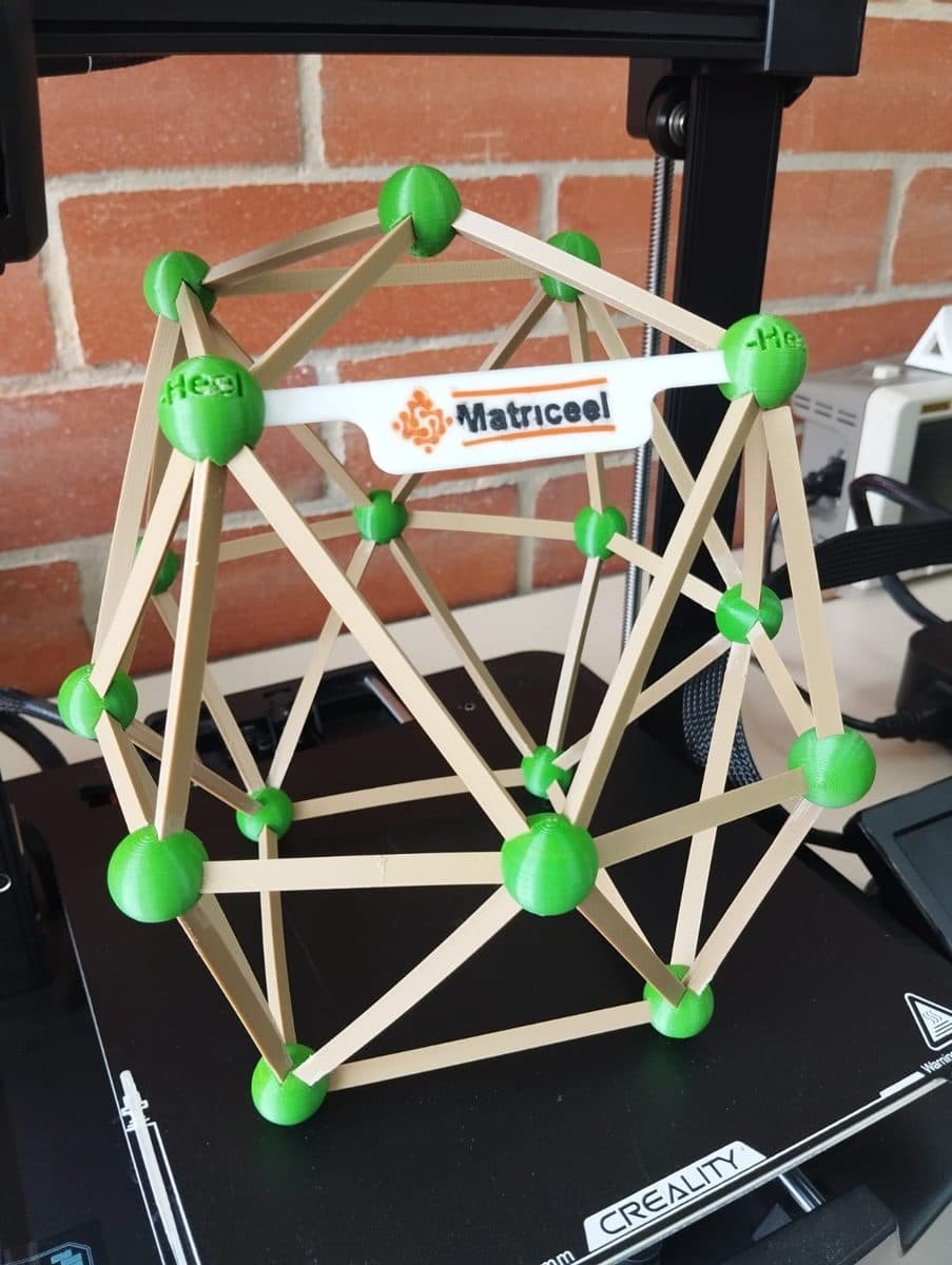 Estructura geodésica con uniones verdes impresas en 3D y varillas de madera